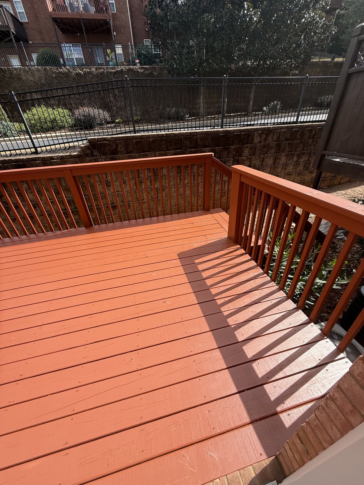 Red-terracotta painted deck with matching railing — Lou's Atlanta Painting