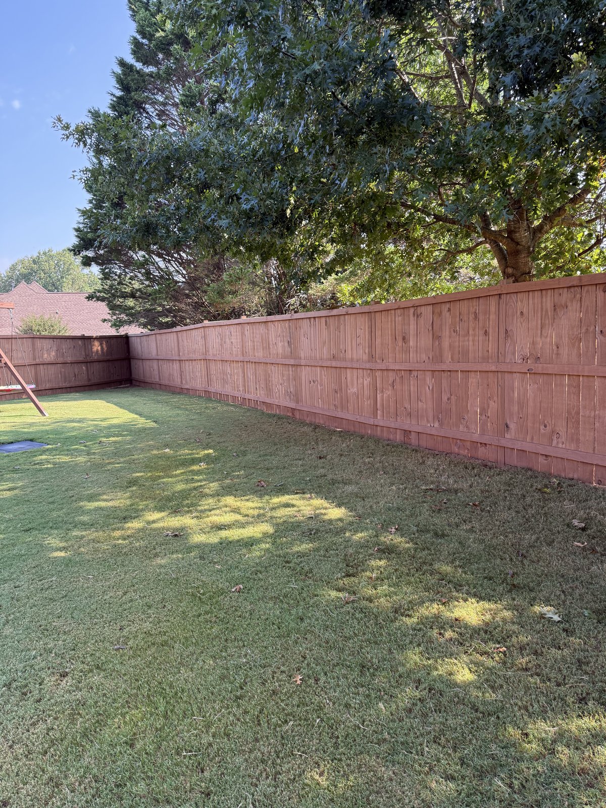 Backyard with a freshly stained red-auburn wood privacy fence — Lou's Atlanta Painting