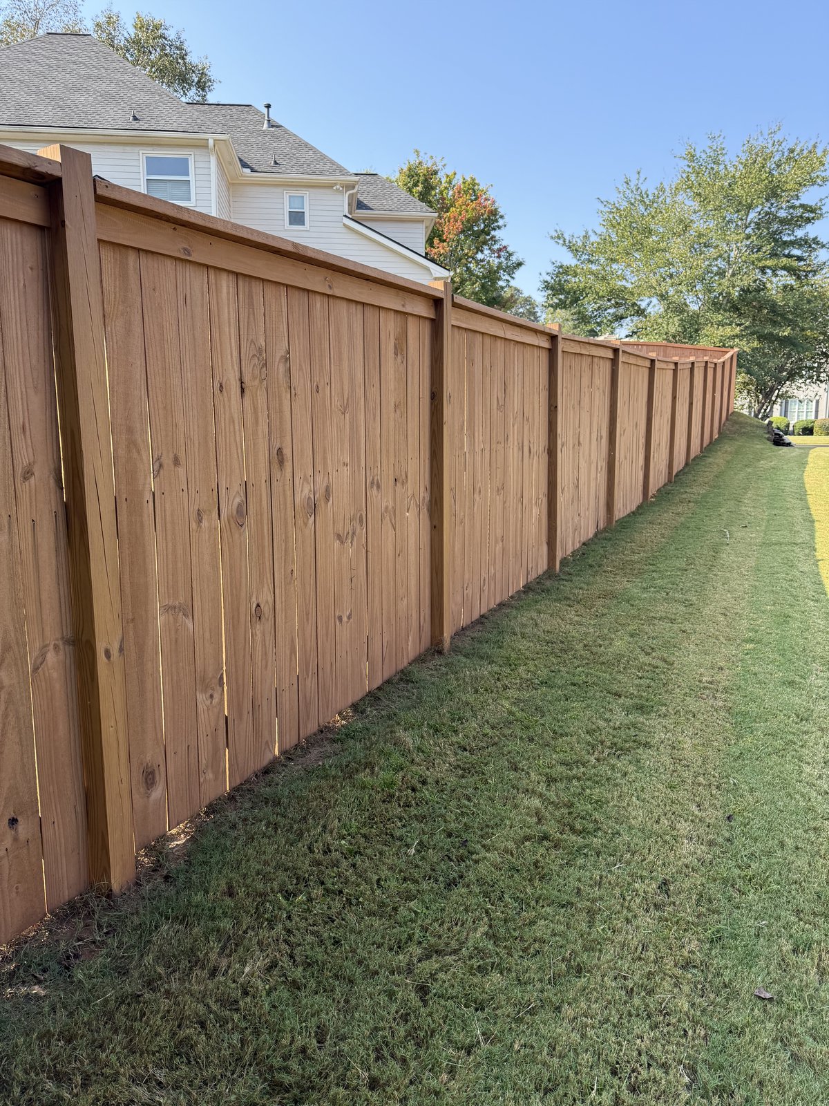 Long wooden privacy fence — fence staining by Lou's Atlanta Painting
