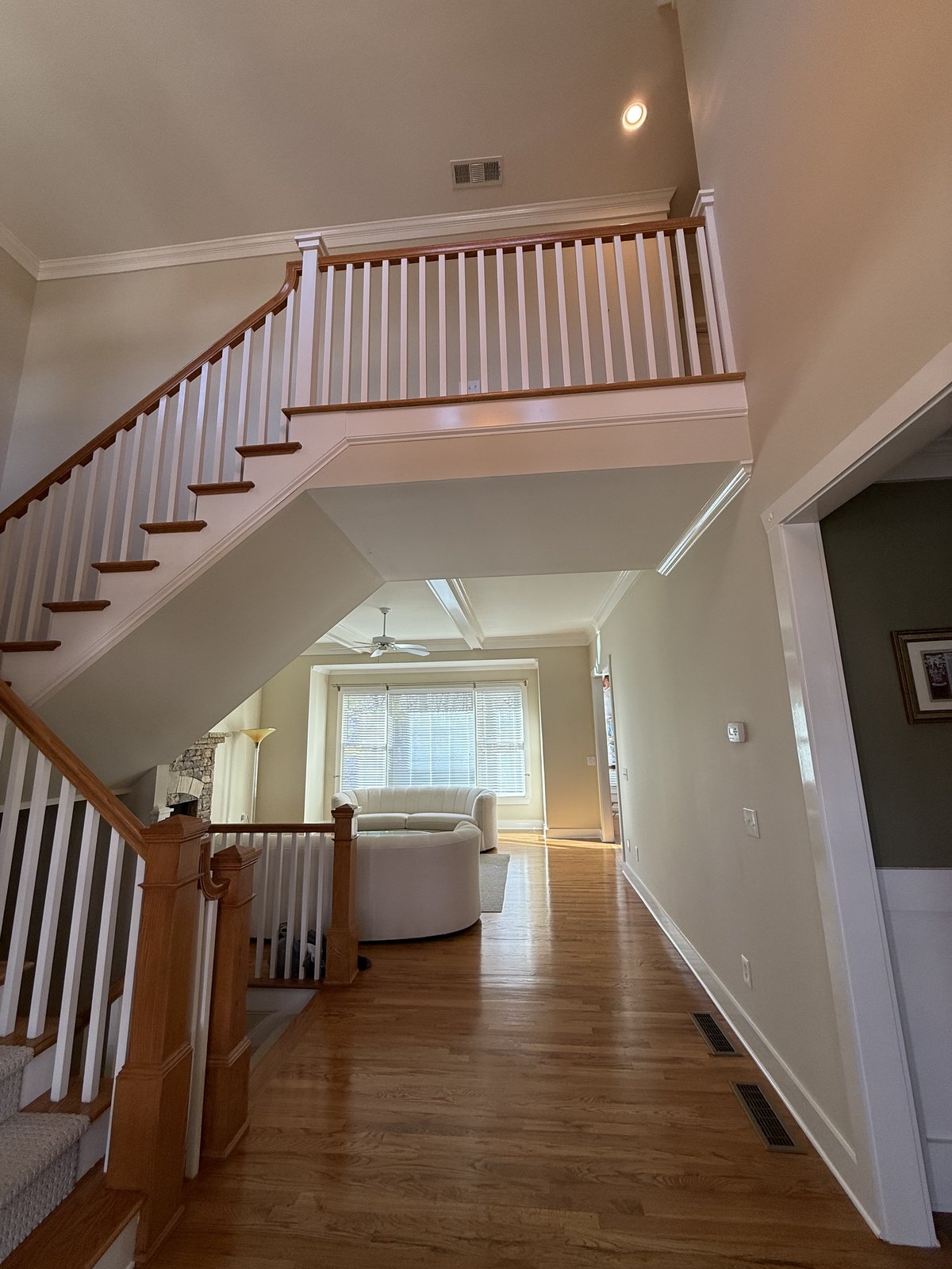 Curved staircase with white walls and dark accent rail — Lou's Atlanta Painting