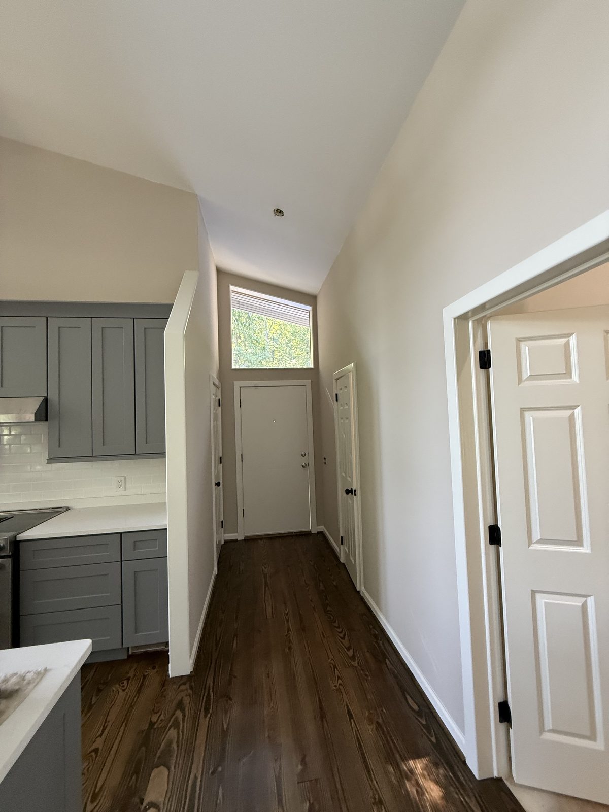 Bright entry hallway with a vaulted ceiling beside a gray shaker kitchen — Lou's Atlanta Painting