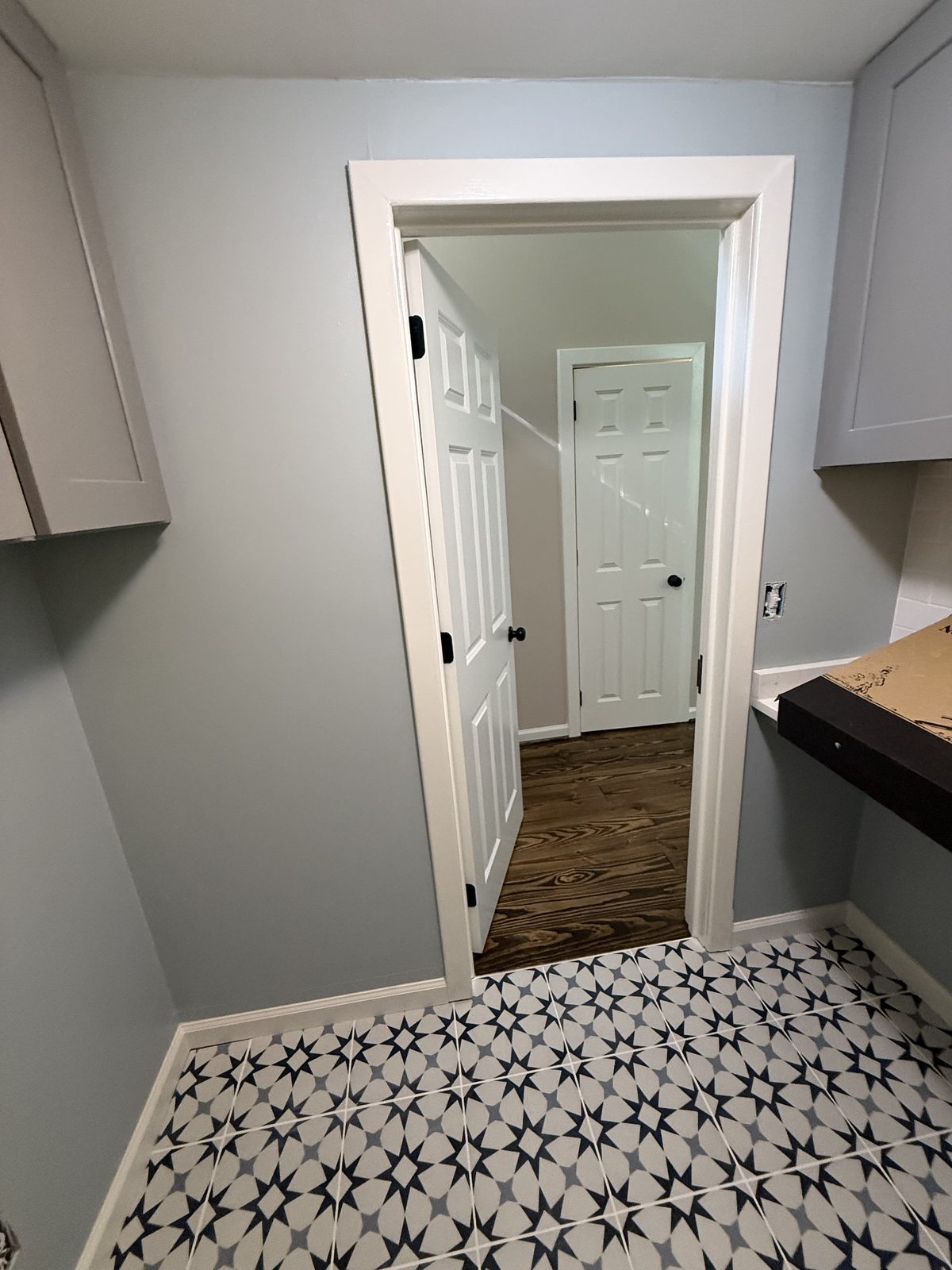 Laundry room with crisp white trim and a black-and-white star tile floor — Lou's Atlanta Painting