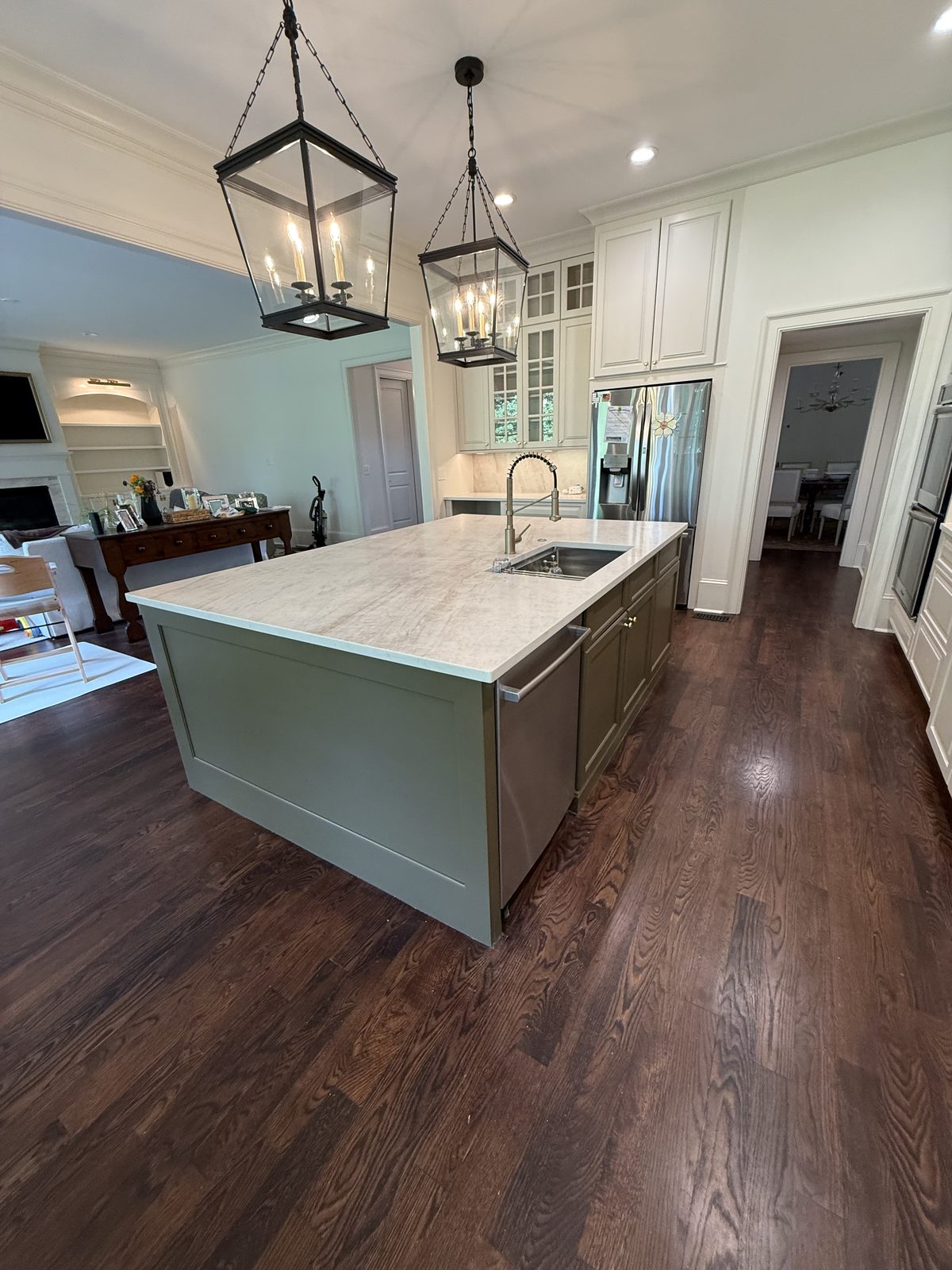 Kitchen island painted deep sage green with a marble top and iron lantern pendants — Lou's Atlanta Painting